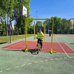 Uczeń pokonujący sprawnościowy tor przeszkód na rowerze.jpg