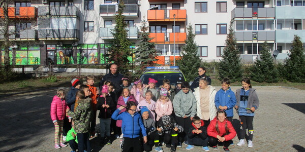 Uczniowie i policjanci podczas zdjęcia pamiątkowego na szkolnym parkingu.JPG