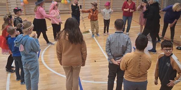 uczniowie podczas tańca z miotłą na zabawie andrzejkowej.jpg