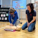 Uczennica pod okiem instruktorki ćwiczy resuscytację oddechowo-krążeniową.jpg