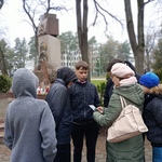 Uczniowie z nauczycielem oglądający zdjęcia miejsc pamięci w innych miastach.jpg