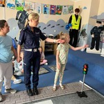 Uczniowie z panią policjantką uczą się prawidłowo przechodzić przez jezdnię.jpg