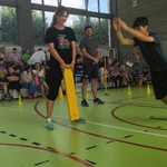 Trenerzy i uczeń wykonujący skok w dal z miejsca podczas zawodów sportowych.jpg
