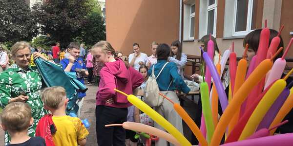 Uczniowie nauczyciele i rodzice na szkolnym placu zabaw podczas pikniku.jpeg